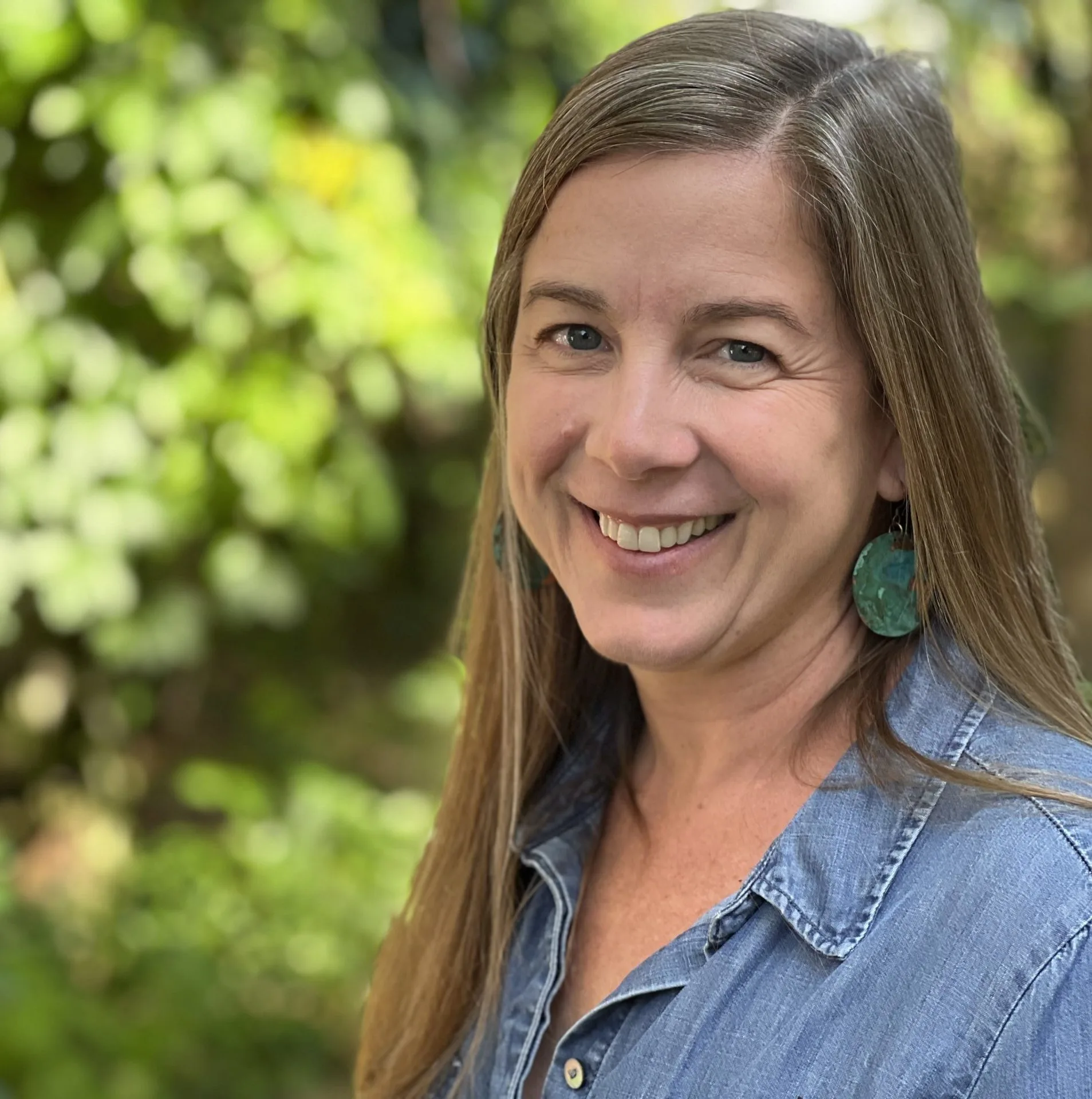headshot of maggie ohalloran against blurred green foliage background